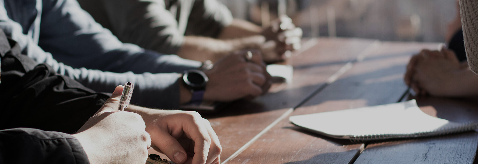 Mehrere Personen arbeiten an einem Tisch