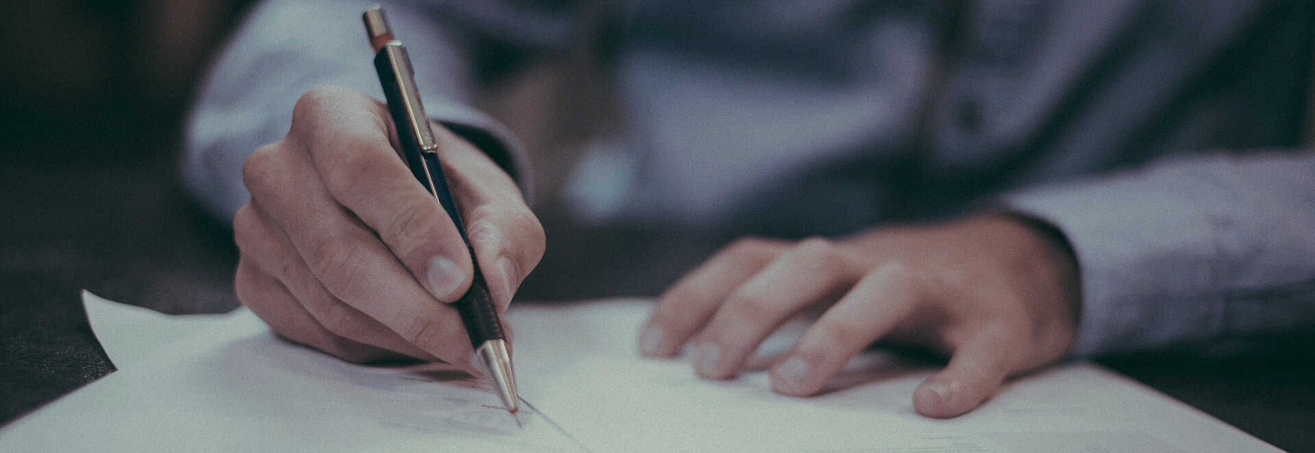 Jemand schreibt etwas auf Papier
