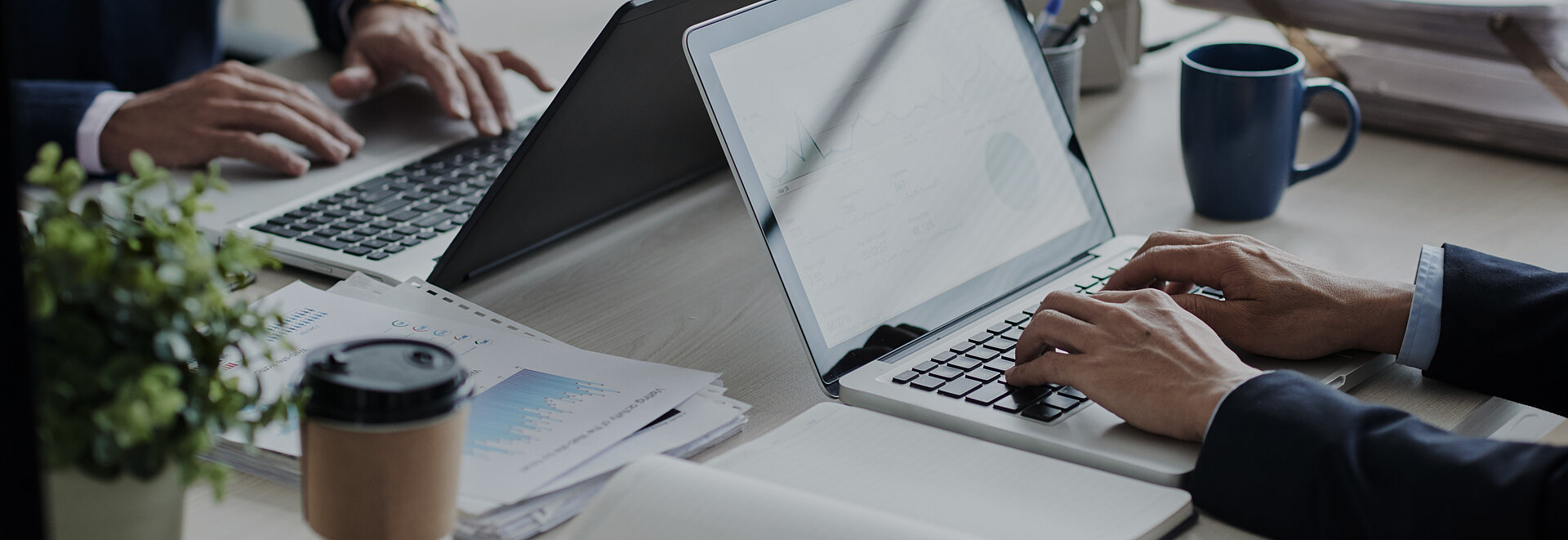 Personen mit Anzug arbeiten an Laptops